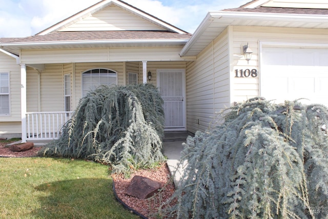 doorway to property with a yard and a garage