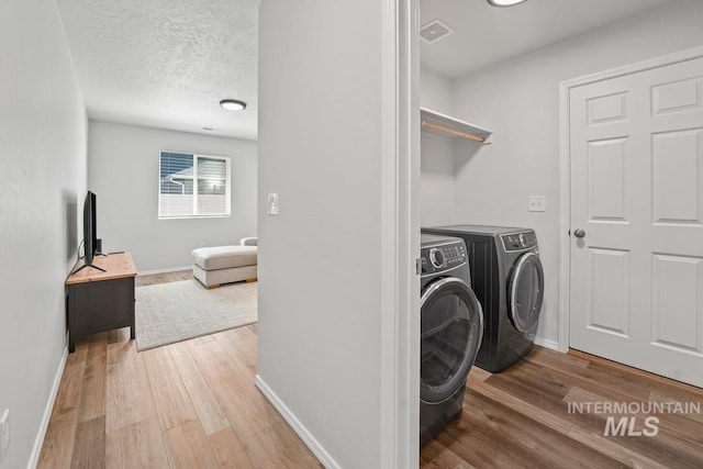 12740 Abbeygate Dr, Nampa, ID 83651 - washroom featuring washer and clothes dryer, wood finished floors, and a textured ceiling
