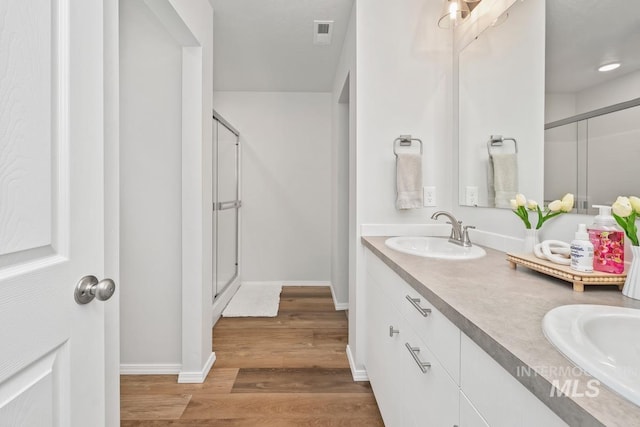 12740 Abbeygate Dr, Nampa, ID 83651 - full bath featuring double vanity, a shower stall, and wood finished floors