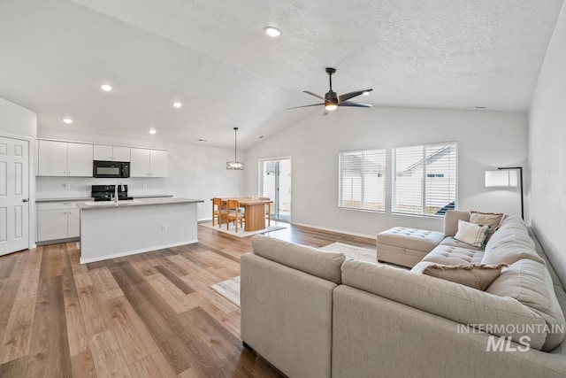 12740 Abbeygate Dr, Nampa, ID 83651 - living room featuring lofted ceiling, light wood-type flooring, a ceiling fan, recessed lighting, and a textured ceiling