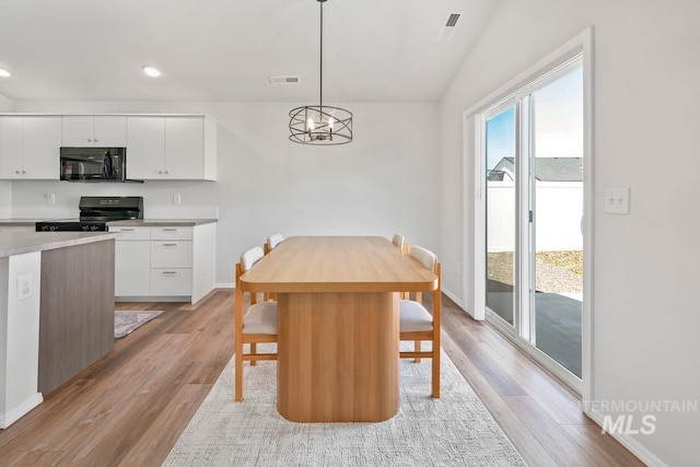 12740 Abbeygate Dr, Nampa, ID 83651 - dining space featuring light wood-type flooring, a chandelier, recessed lighting, and vaulted ceiling