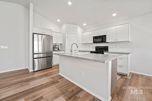 12740 Abbeygate Dr, Nampa, ID 83651 - kitchen with black appliances, lofted ceiling, white cabinetry, light countertops, and recessed lighting