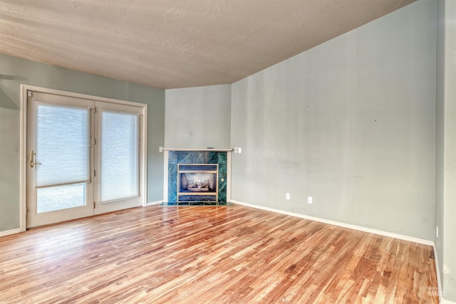 1921 Arcata Way, Ontario, OR 97914 - unfurnished living room featuring wood finished floors, a fireplace, and a textured ceiling