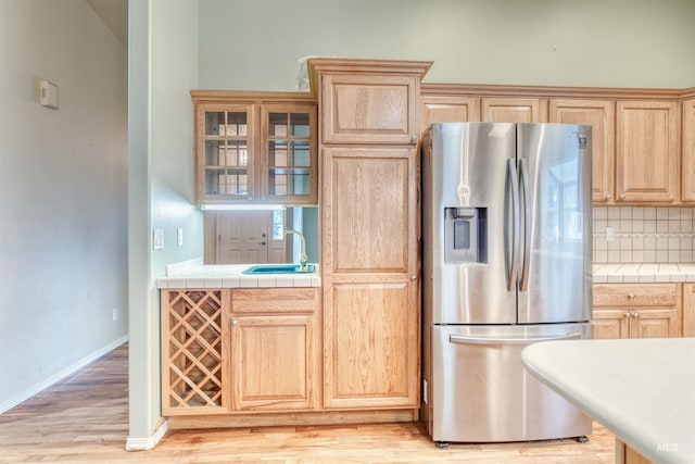 1921 Arcata Way, Ontario, OR 97914 - kitchen with stainless steel fridge with ice dispenser, light brown cabinets, light wood-type flooring, tile countertops, and tasteful backsplash