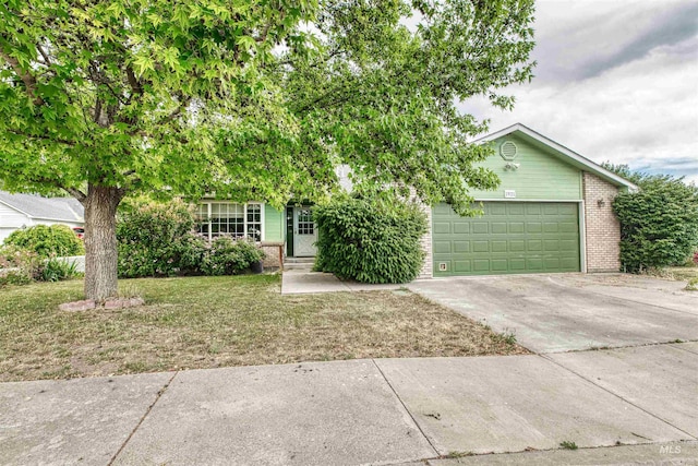 1921 Arcata Way, Ontario, OR 97914 - view of property hidden behind natural elements featuring brick siding, concrete driveway, an attached garage, and a front yard