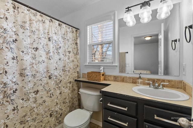 bathroom with curtained shower, toilet, and vanity