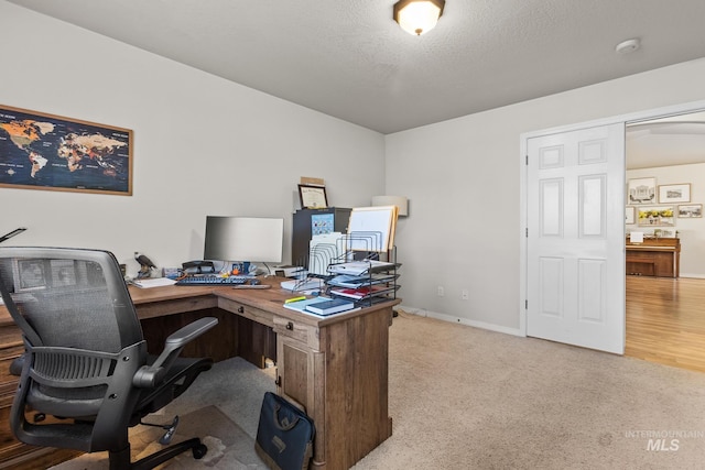 office featuring a textured ceiling and light colored carpet