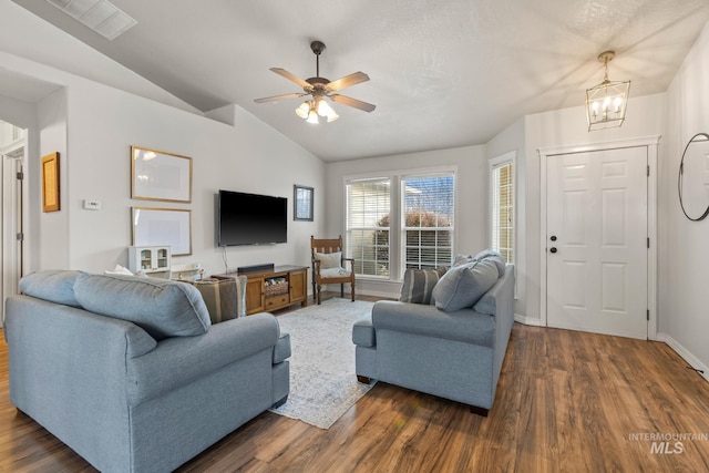 living room with ceiling fan with notable chandelier, dark hardwood / wood-style floors, and vaulted ceiling