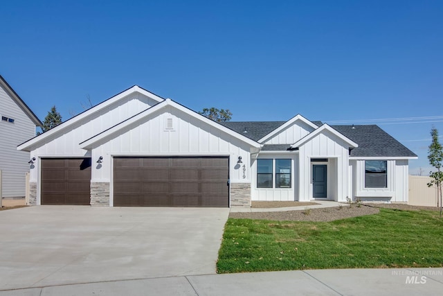 modern inspired farmhouse featuring roof with shingles, an attached garage, board and batten siding, a front yard, and driveway