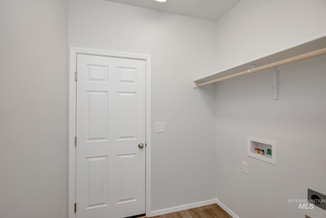 clothes washing area with hookup for a washing machine, light wood-style floors, hookup for an electric dryer, laundry area, and baseboards