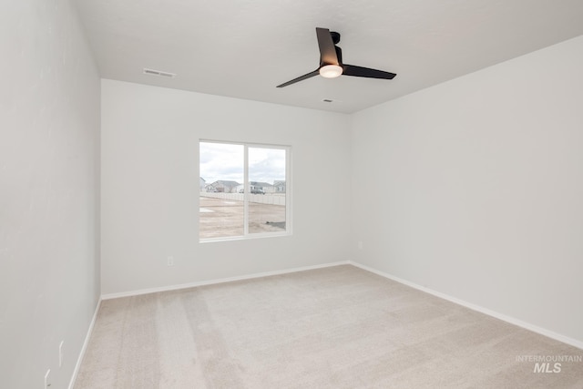 spare room featuring baseboards, visible vents, and light colored carpet