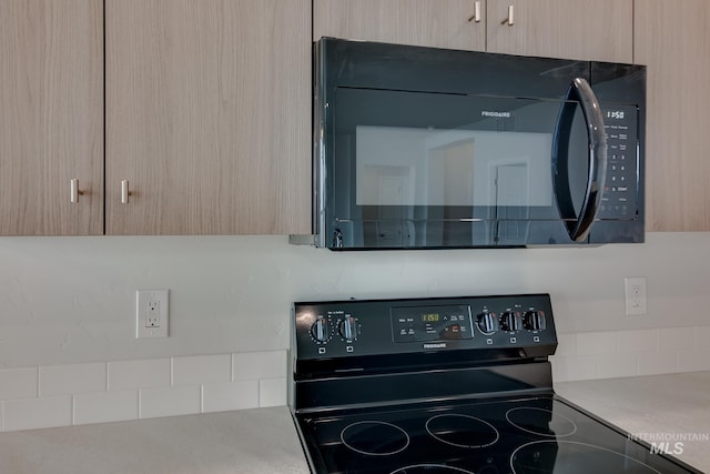 kitchen with light countertops, light brown cabinets, and black appliances