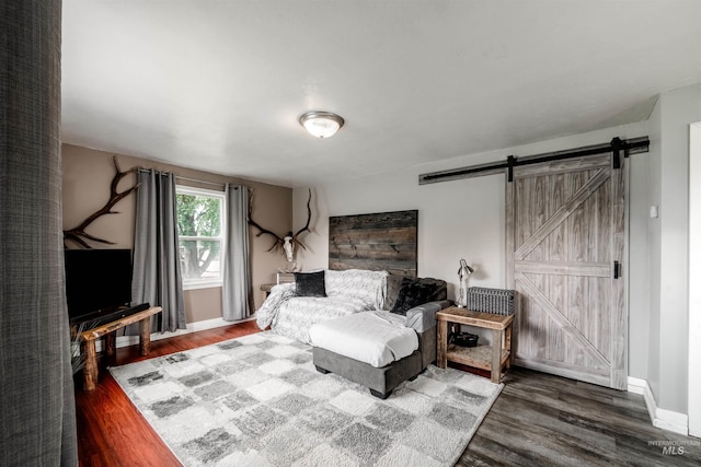 living room with a barn door and dark hardwood / wood-style floors