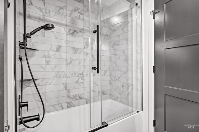 bathroom with bath / shower combo with glass door