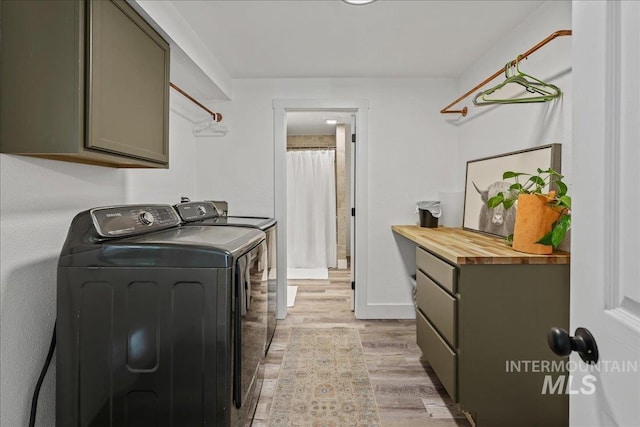 15103 Castle Way, Caldwell, ID 83607 - laundry room with washer and clothes dryer, cabinet space, light wood-style flooring, and baseboards