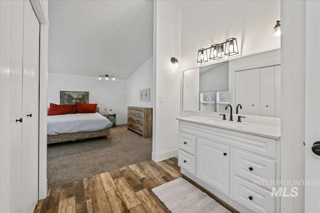 15103 Castle Way, Caldwell, ID 83607 - bathroom with vanity, hardwood / wood-style floors, vaulted ceiling, connected bathroom, and baseboards