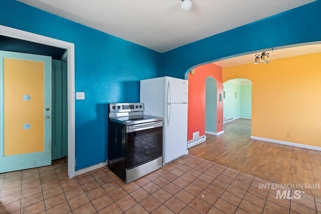 359 Falls Ave W, Twin Falls, ID 83301 - kitchen featuring stainless steel electric range, arched walkways, freestanding refrigerator, a baseboard radiator, and baseboards