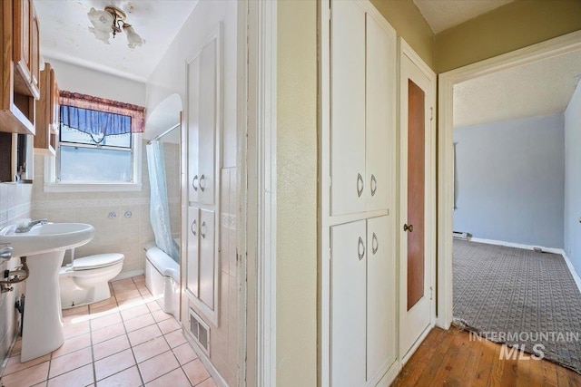 359 Falls Ave W, Twin Falls, ID 83301 - full bathroom featuring shower / bath combo with shower curtain, toilet, a sink, and tile patterned flooring