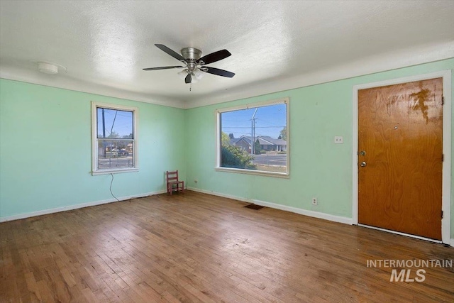 359 Falls Ave W, Twin Falls, ID 83301 - unfurnished room with plenty of natural light, hardwood / wood-style flooring, a ceiling fan, and baseboards