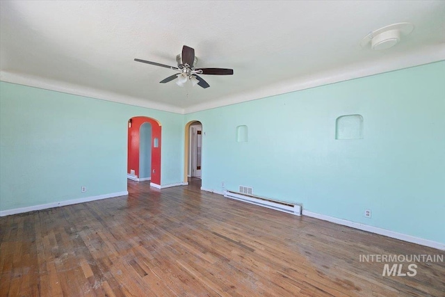 359 Falls Ave W, Twin Falls, ID 83301 - unfurnished room featuring a baseboard heating unit, a ceiling fan, wood finished floors, arched walkways, and baseboards