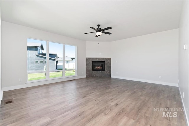 6150 S Binky Ave, Meridian, ID 83642 - unfurnished living room featuring ceiling fan, light wood-style floors, a fireplace, and baseboards
