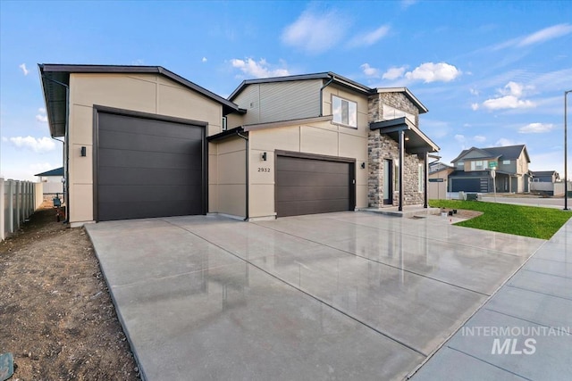 6150 S Binky Ave, Meridian, ID 83642 - modern home with concrete driveway, a garage, stone siding, and stucco siding
