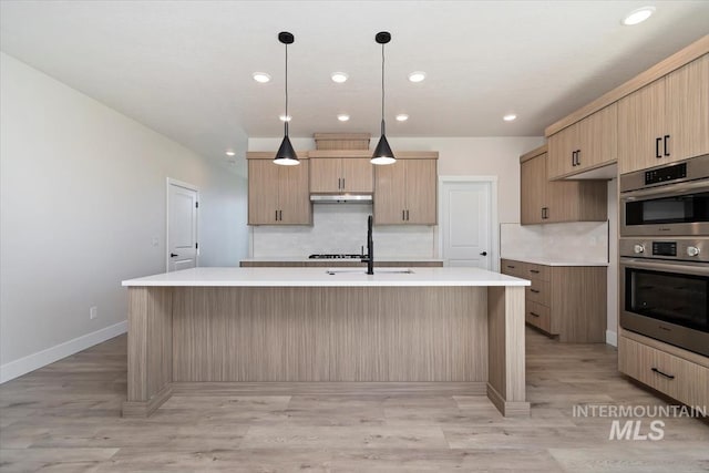6150 S Binky Ave, Meridian, ID 83642 - kitchen with double oven, under cabinet range hood, a sink, tasteful backsplash, and light countertops