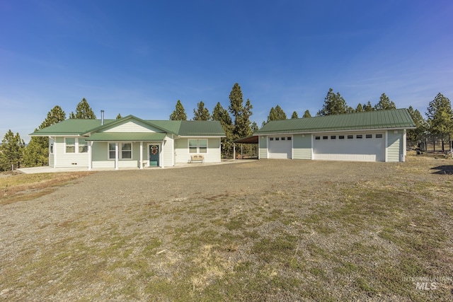 ranch-style house featuring a detached garage, metal roof, and an outdoor structure