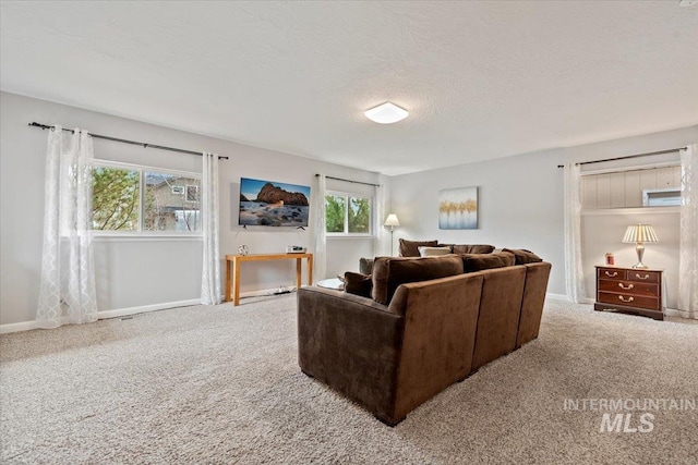 living area with carpet, a textured ceiling, and baseboards