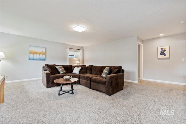 living area featuring carpet, a textured ceiling, and baseboards