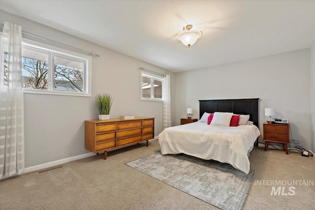 bedroom with light carpet, visible vents, and baseboards