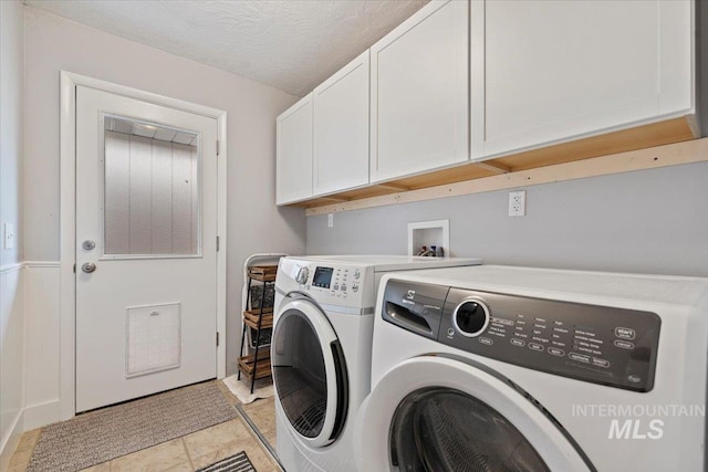 laundry room with cabinet space, washer and clothes dryer, and a textured ceiling