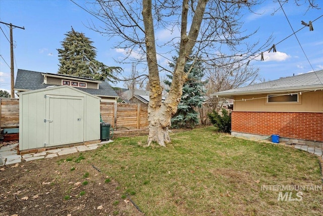 view of yard featuring a storage unit, an outdoor structure, and fence