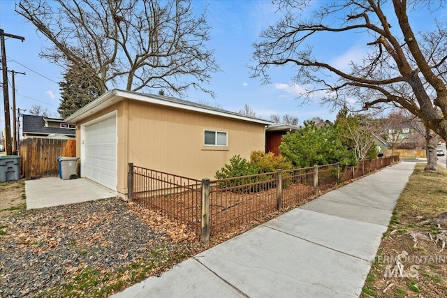 view of home's exterior with a fenced front yard and a detached garage