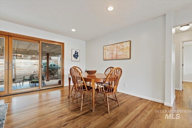 dining area featuring a textured ceiling, recessed lighting, light wood-type flooring, and baseboards