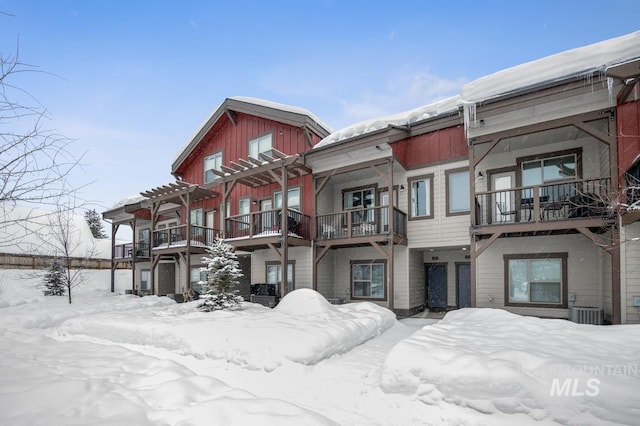 snow covered property with central AC unit