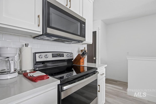 kitchen featuring white cabinetry, light hardwood / wood-style flooring, appliances with stainless steel finishes, and tasteful backsplash