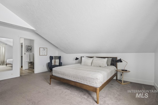 carpeted bedroom featuring lofted ceiling and a textured ceiling