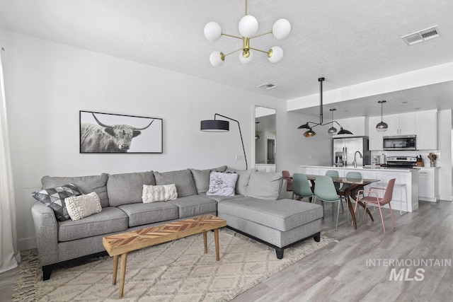 living room with a textured ceiling and light hardwood / wood-style flooring