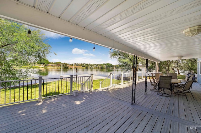 wooden deck with a water view and a yard