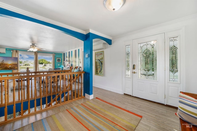 foyer featuring wood-type flooring, ceiling fan, and crown molding