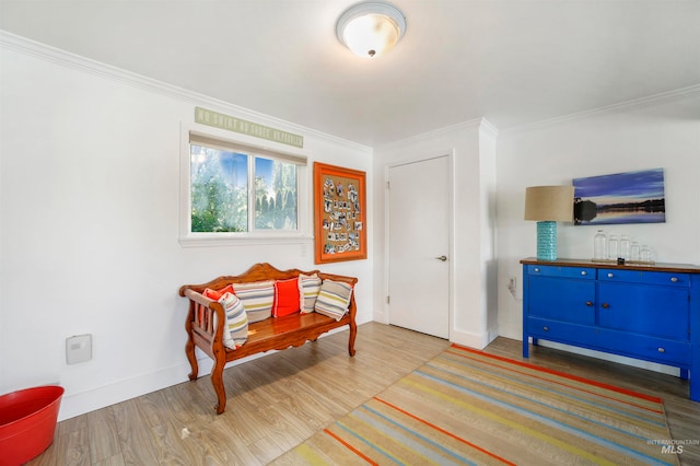 living area with light hardwood / wood-style flooring and ornamental molding