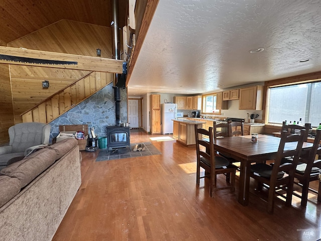 532 Warren Creek Rd, Warren, ID 83671 - dining area featuring lofted ceiling, a wood stove, wood finished floors, and wood walls
