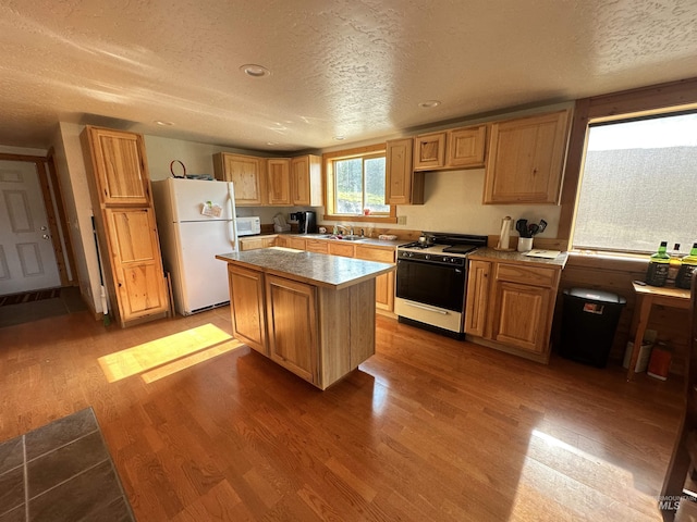 532 Warren Creek Rd, Warren, ID 83671 - kitchen featuring white appliances, wood finished floors, a textured ceiling, a kitchen island, and light countertops