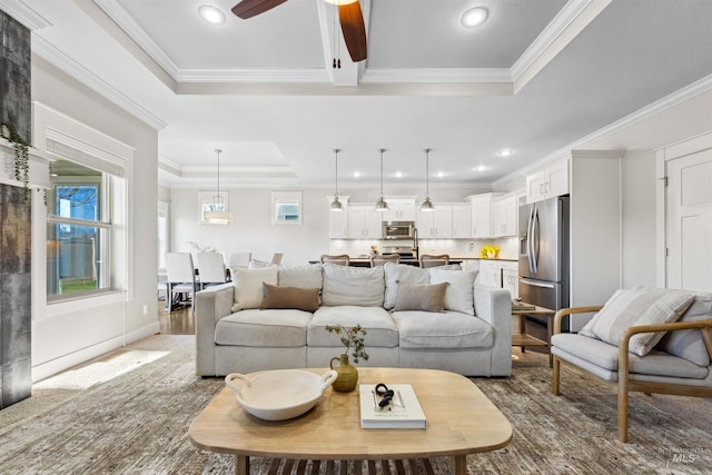 carpeted living room with crown molding, ceiling fan, and a raised ceiling