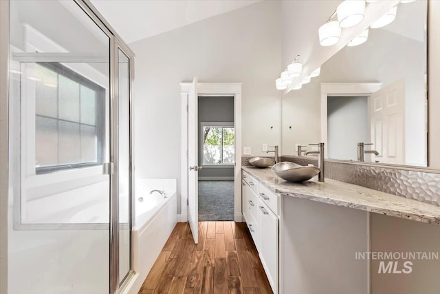 2249 N Eagle Creek Ln, Eagle, ID 83616 - bathroom with wood finished floors, double vanity, a bath, a stall shower, and a chandelier