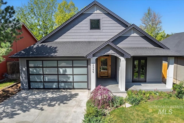 2249 N Eagle Creek Ln, Eagle, ID 83616 - view of front of property featuring driveway, an attached garage, a shingled roof, french doors, and a porch