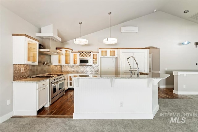 2249 N Eagle Creek Ln, Eagle, ID 83616 - kitchen featuring range with two ovens, glass insert cabinets, white cabinetry, a kitchen breakfast bar, and tasteful backsplash