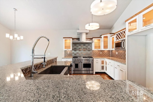 2249 N Eagle Creek Ln, Eagle, ID 83616 - kitchen featuring appliances with stainless steel finishes, a sink, island exhaust hood, decorative backsplash, and a chandelier