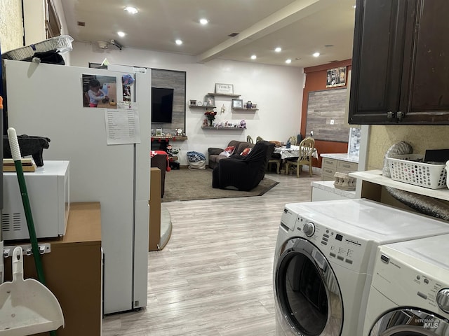 laundry area with washer and dryer and light wood-type flooring